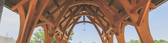 Timber pavilion with exposed wooden beams and arched architecture at Deer Creek Lodge.